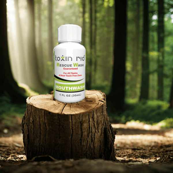 A bottle of Toxin Rid detox mouthwash on a tree stump in the forest